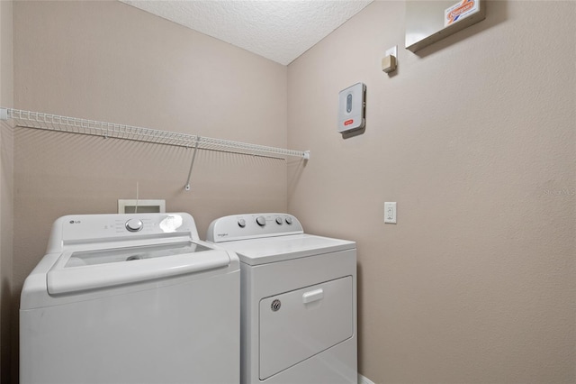 1030 Bending Oak Trl, Winter Garden, FL 34787 - laundry room featuring washing machine and clothes dryer and a textured ceiling