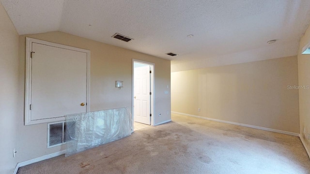 3552 Macauley Ct, Ocoee, FL 34761 - empty room with light carpet, vaulted ceiling, and a textured ceiling