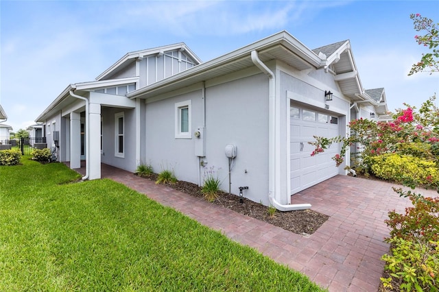 2302 Datura Loop, Saint Cloud, FL 34772 - view of side of property featuring a garage, stucco siding, and decorative driveway