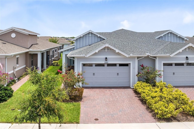 2302 Datura Loop, Saint Cloud, FL 34772 - view of front of property featuring a shingled roof, an attached garage, and decorative driveway