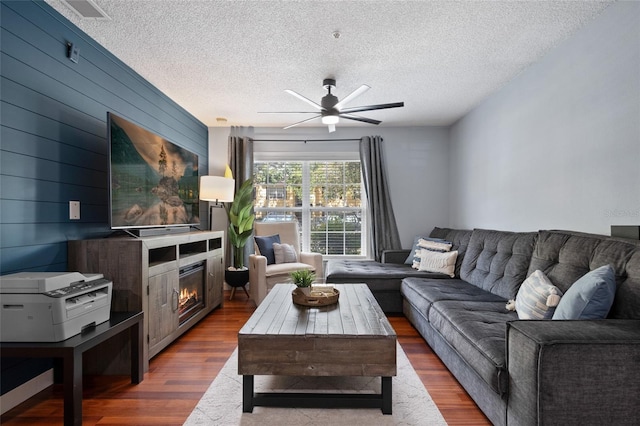 2035 Dixie Belle Dr Unit 2035C, Orlando, FL 32812 - living area featuring a glass covered fireplace, a ceiling fan, wood finished floors, and a textured ceiling