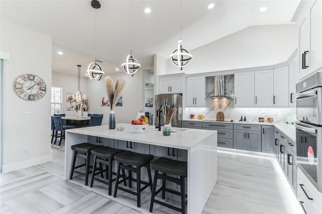 18623 Tunbridge St, Orlando, FL 32833 - kitchen featuring stainless steel appliances, a kitchen breakfast bar, vaulted ceiling, backsplash, and hanging light fixtures