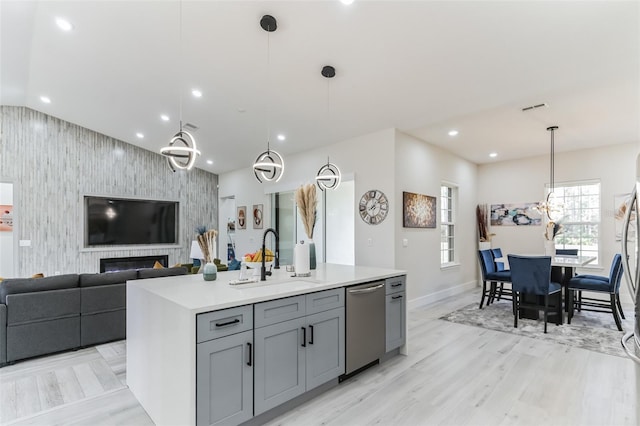 18623 Tunbridge St, Orlando, FL 32833 - kitchen featuring dishwasher, gray cabinets, light countertops, open floor plan, and an accent wall
