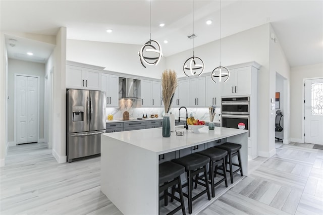 18623 Tunbridge St, Orlando, FL 32833 - kitchen with appliances with stainless steel finishes, wall chimney exhaust hood, a breakfast bar area, decorative light fixtures, and light countertops