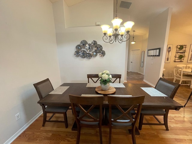 8071 Roaring Creek Ct, Kissimmee, FL 34747 - dining area with a chandelier, light wood-style floors, and lofted ceiling