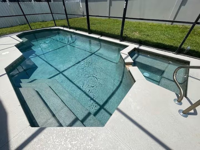 8071 Roaring Creek Ct, Kissimmee, FL 34747 - view of swimming pool featuring glass enclosure and a pool with connected hot tub