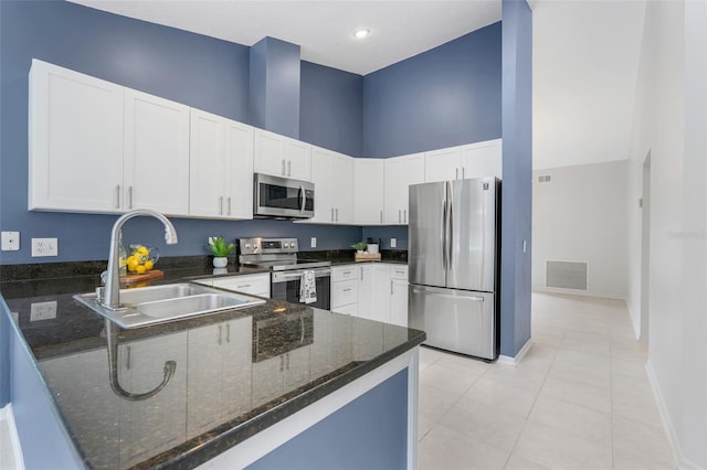1173 Trotwood Blvd, Winter Springs, FL 32708 - kitchen with stainless steel appliances, dark stone countertops, a peninsula, light tile patterned flooring, and a towering ceiling
