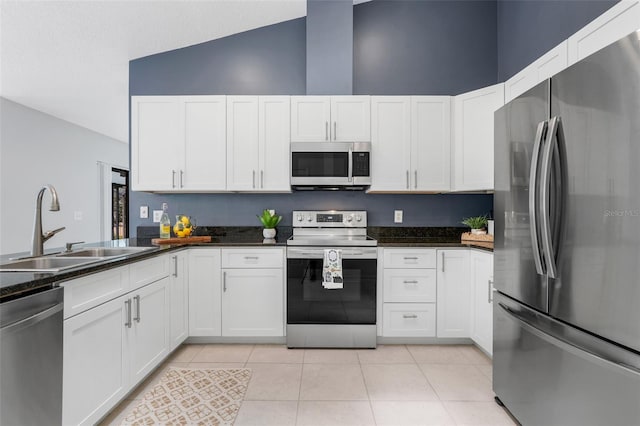 1173 Trotwood Blvd, Winter Springs, FL 32708 - kitchen featuring stainless steel appliances, light tile patterned floors, high vaulted ceiling, and white cabinetry