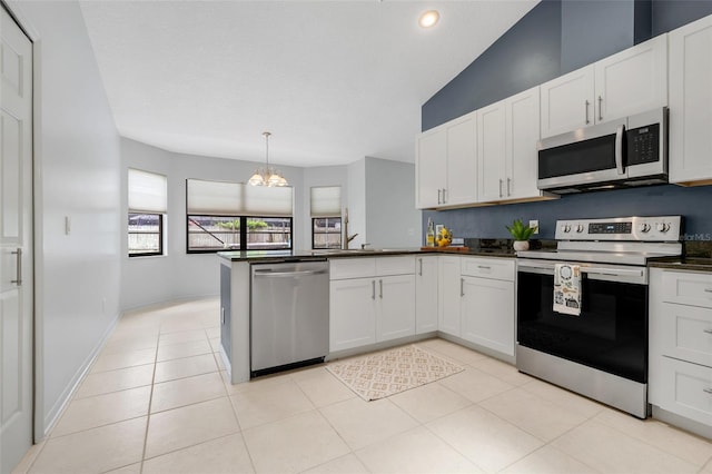 1173 Trotwood Blvd, Winter Springs, FL 32708 - kitchen with appliances with stainless steel finishes, dark countertops, a chandelier, a peninsula, and white cabinets
