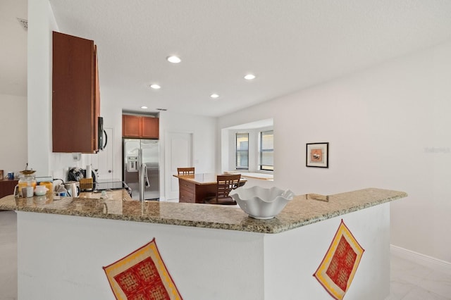 2982 Camino Real Dr S, Kissimmee, FL 34744 - kitchen featuring stainless steel fridge with ice dispenser, recessed lighting, a peninsula, light stone counters, and a kitchen island