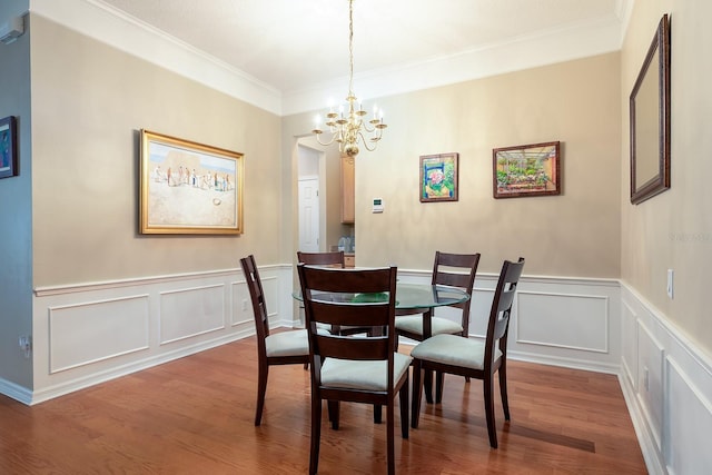 6631 Crestmont Glen Ln, Windermere, FL 34786 - dining room featuring a chandelier, wood finished floors, ornamental molding, a decorative wall, and wainscoting