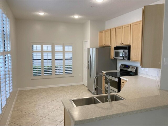 949 Westpark Dr Unit 107, Celebration, FL 34747 - kitchen with appliances with stainless steel finishes, light tile patterned floors, light brown cabinetry, healthy amount of natural light, and recessed lighting