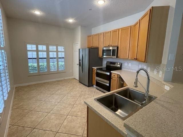 949 Westpark Dr Unit 107, Celebration, FL 34747 - kitchen with stainless steel appliances, light tile patterned flooring, light countertops, and recessed lighting