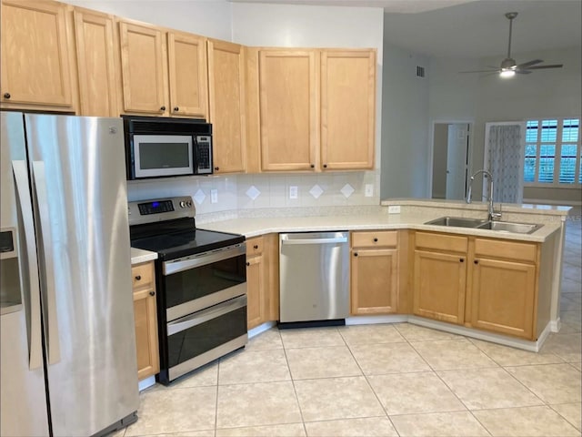 949 Westpark Dr Unit 107, Celebration, FL 34747 - kitchen featuring stainless steel appliances, light brown cabinets, a peninsula, and light countertops