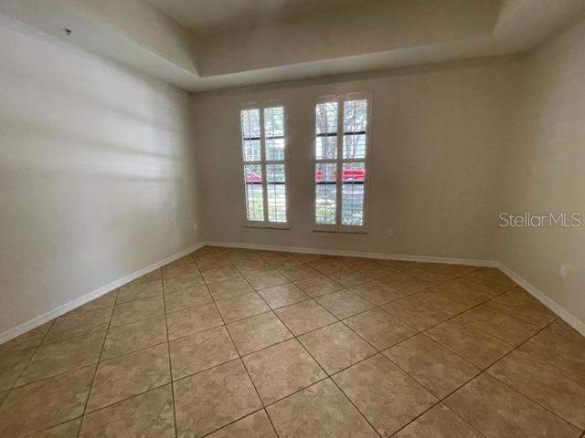 949 Westpark Dr Unit 107, Celebration, FL 34747 - spare room with a raised ceiling and light tile patterned floors