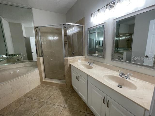 949 Westpark Dr Unit 107, Celebration, FL 34747 - bathroom with double vanity, a bath, tile patterned flooring, and a stall shower