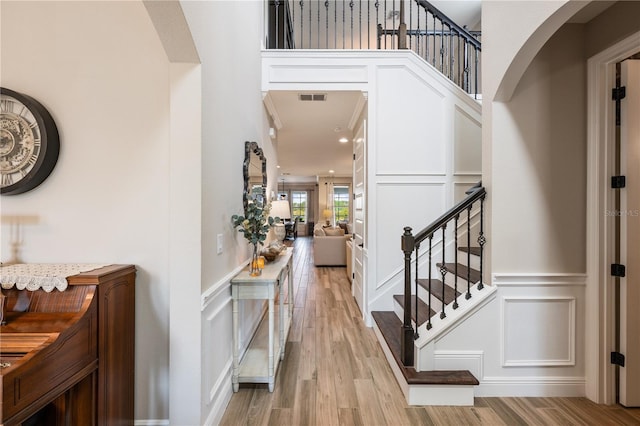 10180 Merrymeeting Bay Dr, Winter Garden, FL 34787 - entrance foyer with a decorative wall, stairway, light wood-type flooring, and a wainscoted wall