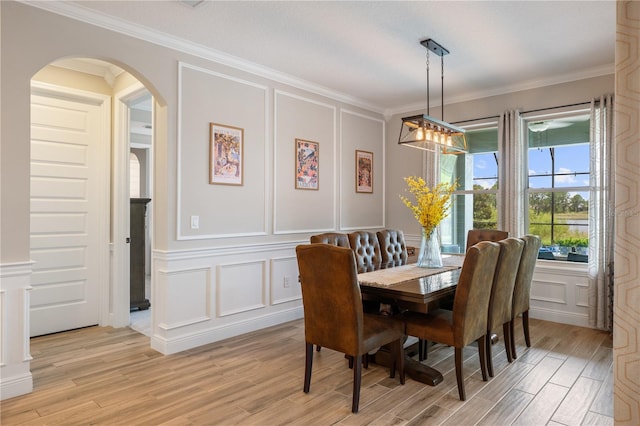 10180 Merrymeeting Bay Dr, Winter Garden, FL 34787 - dining room with a decorative wall, crown molding, light wood-style floors, and arched walkways