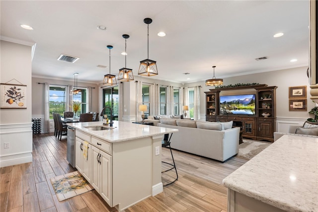 10180 Merrymeeting Bay Dr, Winter Garden, FL 34787 - kitchen featuring crown molding, light stone countertops, a breakfast bar area, dishwasher, and wainscoting