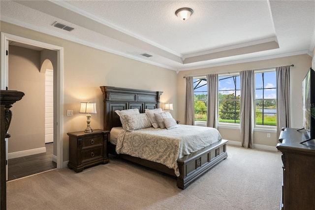 10180 Merrymeeting Bay Dr, Winter Garden, FL 34787 - bedroom featuring a tray ceiling, light carpet, arched walkways, and ornamental molding
