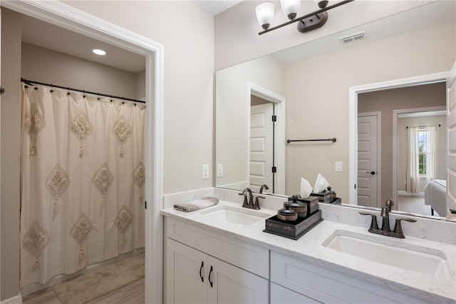 10180 Merrymeeting Bay Dr, Winter Garden, FL 34787 - bathroom with double vanity, wood finished floors, and curtained shower