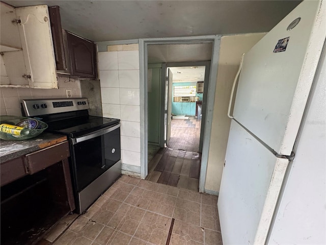 269 12th Ave, Ocoee, FL 34761 - kitchen featuring stainless steel electric range, freestanding refrigerator, dark countertops, and tile patterned floors