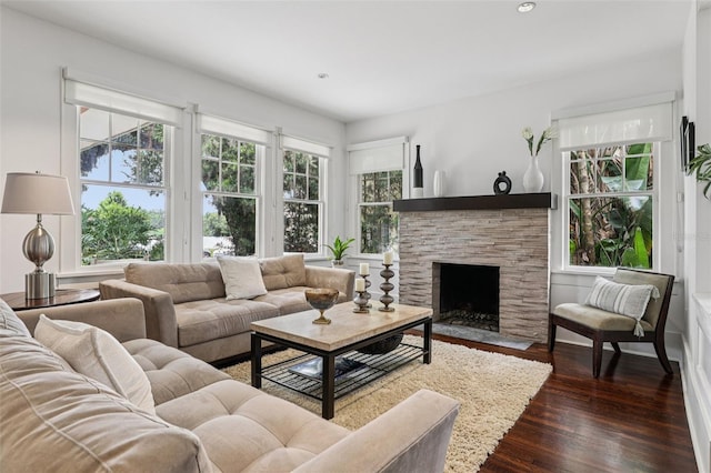213 Phillips Pl, Orlando, FL 32806 - living room with dark wood-style floors, a stone fireplace, and recessed lighting