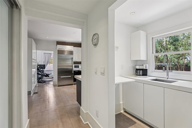 213 Phillips Pl, Orlando, FL 32806 - kitchen with built in fridge, white microwave, light countertops, white cabinetry, and wall oven