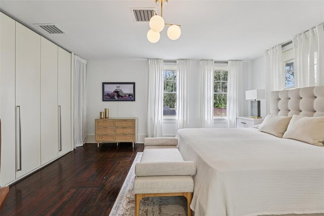 213 Phillips Pl, Orlando, FL 32806 - bedroom featuring multiple windows, dark wood-style floors, and a chandelier