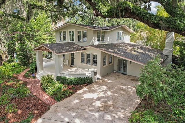 213 Phillips Pl, Orlando, FL 32806 - view of front facade featuring driveway, stucco siding, french doors, and roof with shingles
