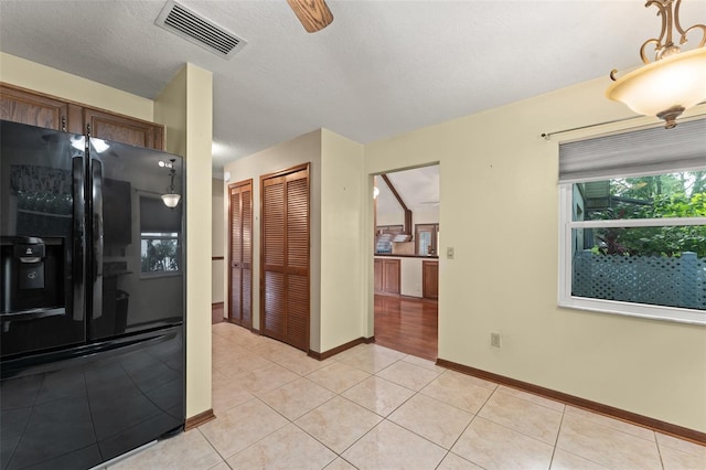 3310 Tall Timber Dr, Orlando, FL 32812 - kitchen featuring black refrigerator with ice dispenser, light tile patterned floors, and dishwasher