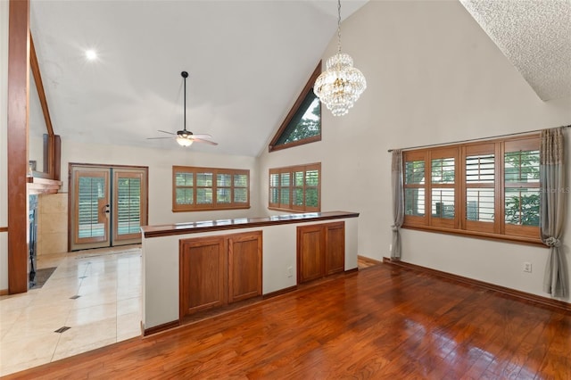 3310 Tall Timber Dr, Orlando, FL 32812 - kitchen featuring high vaulted ceiling, brown cabinets, ceiling fan, light wood-style flooring, and decorative light fixtures