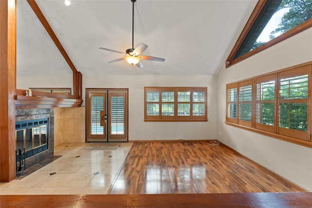 3310 Tall Timber Dr, Orlando, FL 32812 - unfurnished living room with ceiling fan, a tiled fireplace, beam ceiling, high vaulted ceiling, and wood finished floors