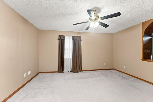 3310 Tall Timber Dr, Orlando, FL 32812 - spare room with light colored carpet, a textured ceiling, a ceiling fan, and arched walkways