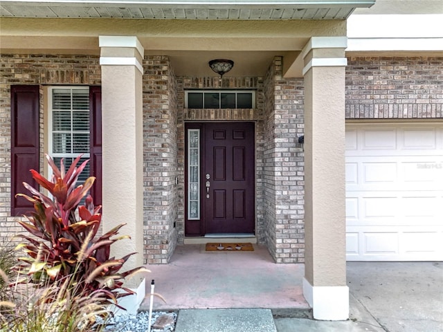 238 Hunt St, Clermont, FL 34711 - property entrance featuring a garage, stucco siding, a porch, and brick siding