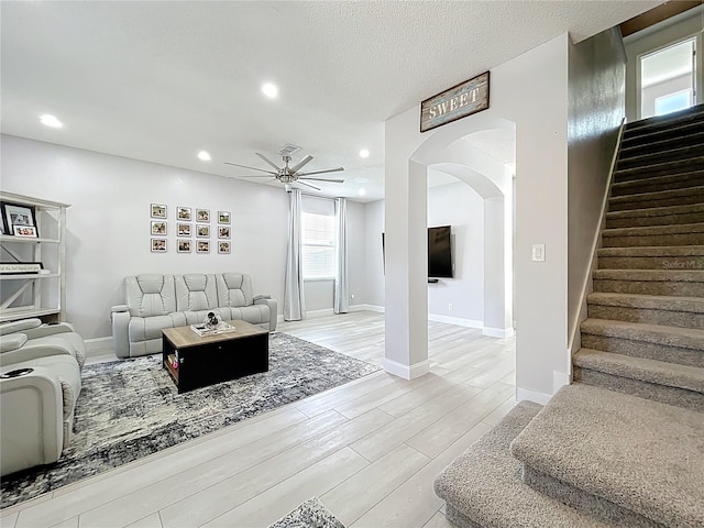 238 Hunt St, Clermont, FL 34711 - living room featuring arched walkways, ceiling fan, stairway, light wood finished floors, and recessed lighting