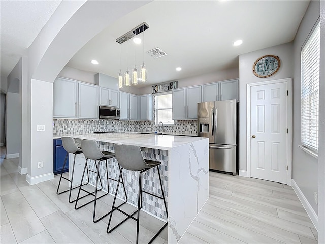238 Hunt St, Clermont, FL 34711 - kitchen with appliances with stainless steel finishes, a breakfast bar area, backsplash, a center island, and recessed lighting
