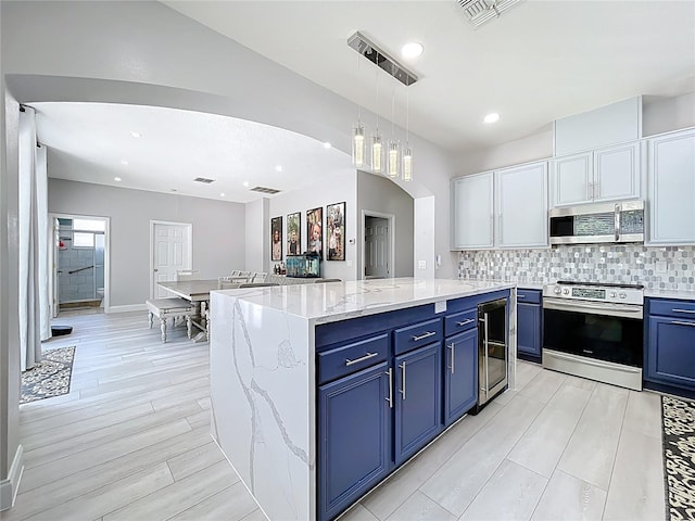 238 Hunt St, Clermont, FL 34711 - kitchen with stainless steel appliances, blue cabinets, beverage cooler, decorative backsplash, and light wood-style flooring