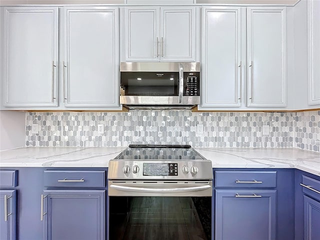 238 Hunt St, Clermont, FL 34711 - kitchen with appliances with stainless steel finishes, blue cabinetry, tasteful backsplash, light stone countertops, and white cabinetry