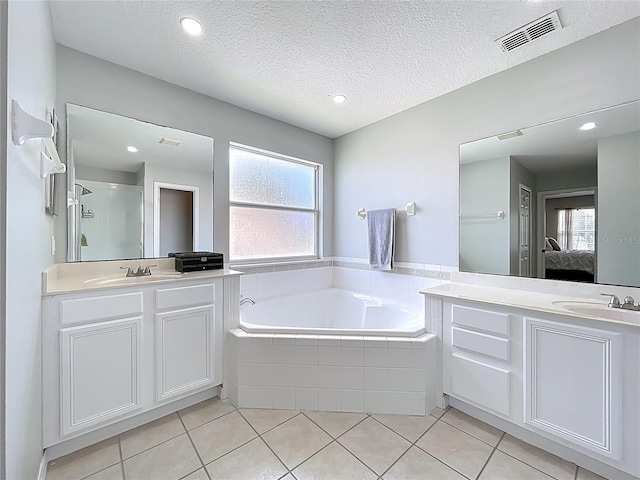 238 Hunt St, Clermont, FL 34711 - ensuite bathroom with a garden tub, two vanities, tile patterned flooring, a stall shower, and a textured ceiling