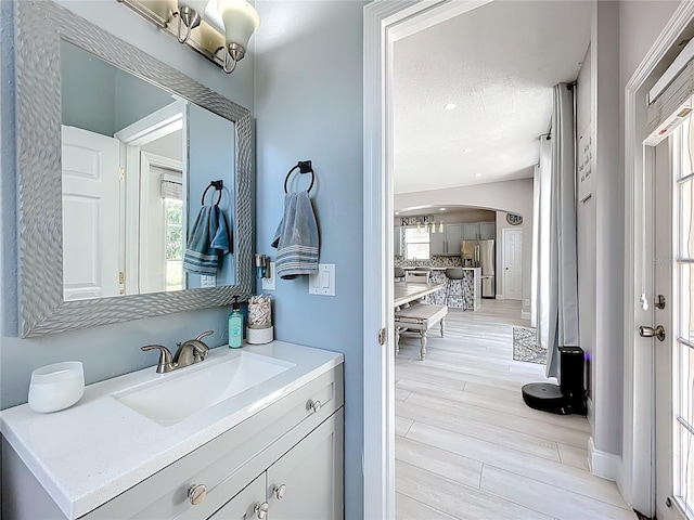 238 Hunt St, Clermont, FL 34711 - bathroom featuring vanity, plenty of natural light, decorative backsplash, and wood finished floors