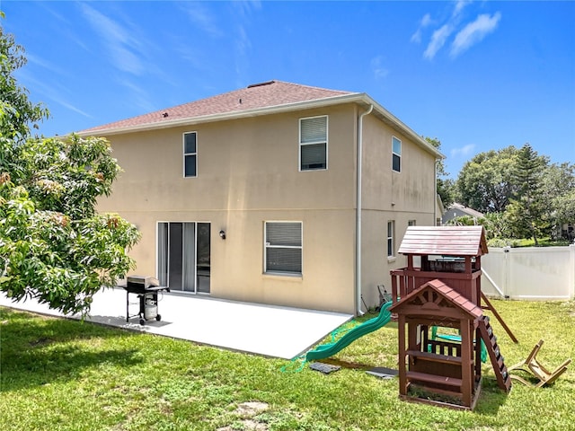 238 Hunt St, Clermont, FL 34711 - back of house featuring a playground, stucco siding, a patio area, and roof with shingles