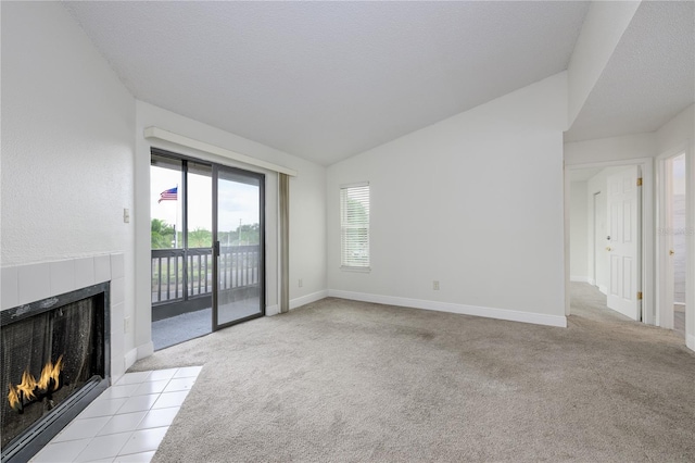 3700 Idlebrook Cir Unit 200, Casselberry, FL 32707 - unfurnished living room featuring a tiled fireplace, lofted ceiling, and carpet flooring