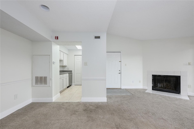 3700 Idlebrook Cir Unit 200, Casselberry, FL 32707 - unfurnished living room featuring light carpet, a tiled fireplace, and lofted ceiling