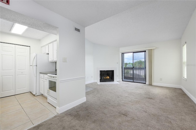 3700 Idlebrook Cir Unit 200, Casselberry, FL 32707 - kitchen featuring healthy amount of natural light, white appliances, white cabinets, a fireplace with flush hearth, and a textured ceiling