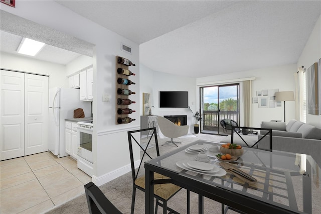 3700 Idlebrook Cir Unit 200, Casselberry, FL 32707 - dining area with a glass covered fireplace, a textured ceiling, light tile patterned flooring, and light carpet
