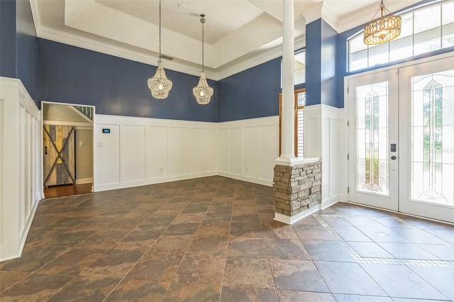 1818 W Cobblestone Ln, Saint Augustine, FL 32092 - foyer entrance with a decorative wall, a chandelier, stone tile floors, a wainscoted wall, and french doors