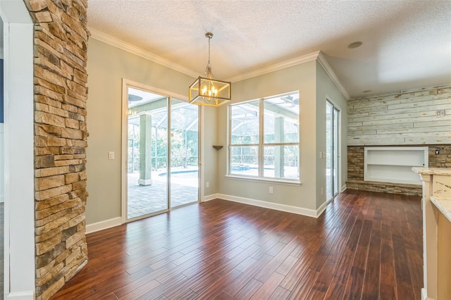 1818 W Cobblestone Ln, Saint Augustine, FL 32092 - unfurnished dining area featuring a textured ceiling, dark wood finished floors, a chandelier, a fireplace, and crown molding