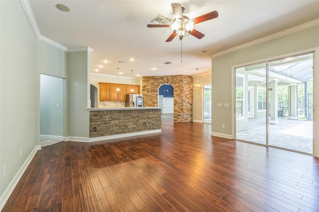 1818 W Cobblestone Ln, Saint Augustine, FL 32092 - unfurnished living room featuring ceiling fan, crown molding, dark wood-type flooring, a textured ceiling, and arched walkways