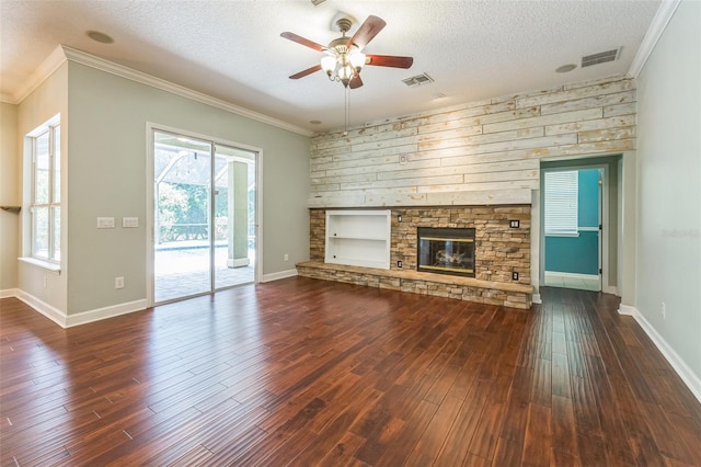 1818 W Cobblestone Ln, Saint Augustine, FL 32092 - unfurnished living room featuring a ceiling fan, a textured ceiling, ornamental molding, dark wood-style flooring, and a stone fireplace